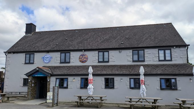 A traditional pub featuring outdoor seating and decorative signs.