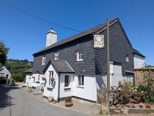 Traditional two-storey house with a black and white exterior along a quiet road.
